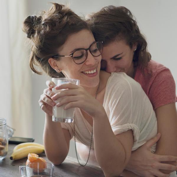Ein lesbisches Paar umarmt sich und lacht.
